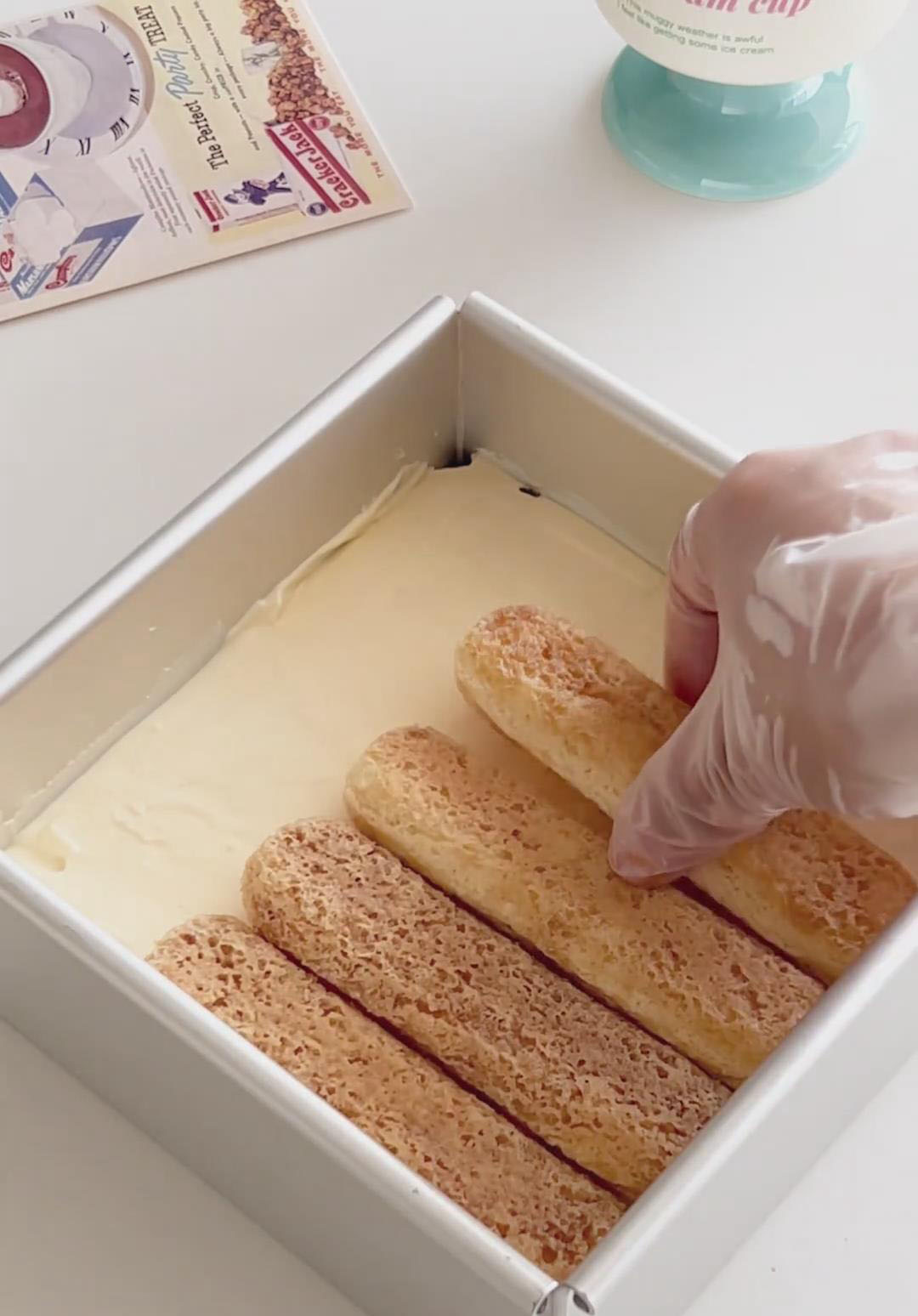 Create a second layer of coffee dipped ladyfingers on top of the cream