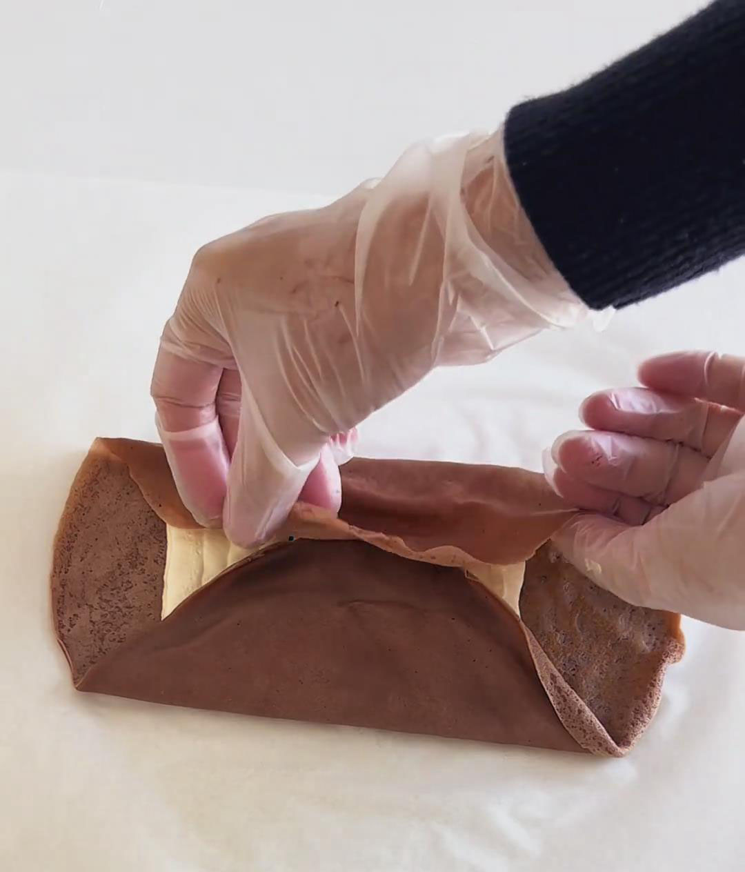 Fold the left and right sides inward to cover the cream