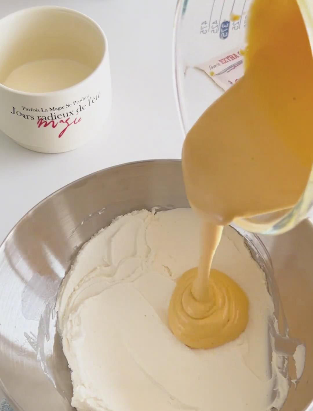 Pour the cooled, room temperature egg yolk mixture into the bowl with the smoothed mascarpone