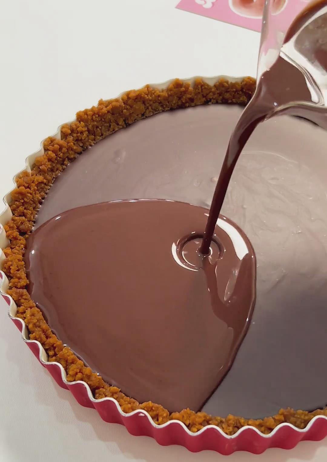 Pour the glaze gently over the fully set chocolate filling