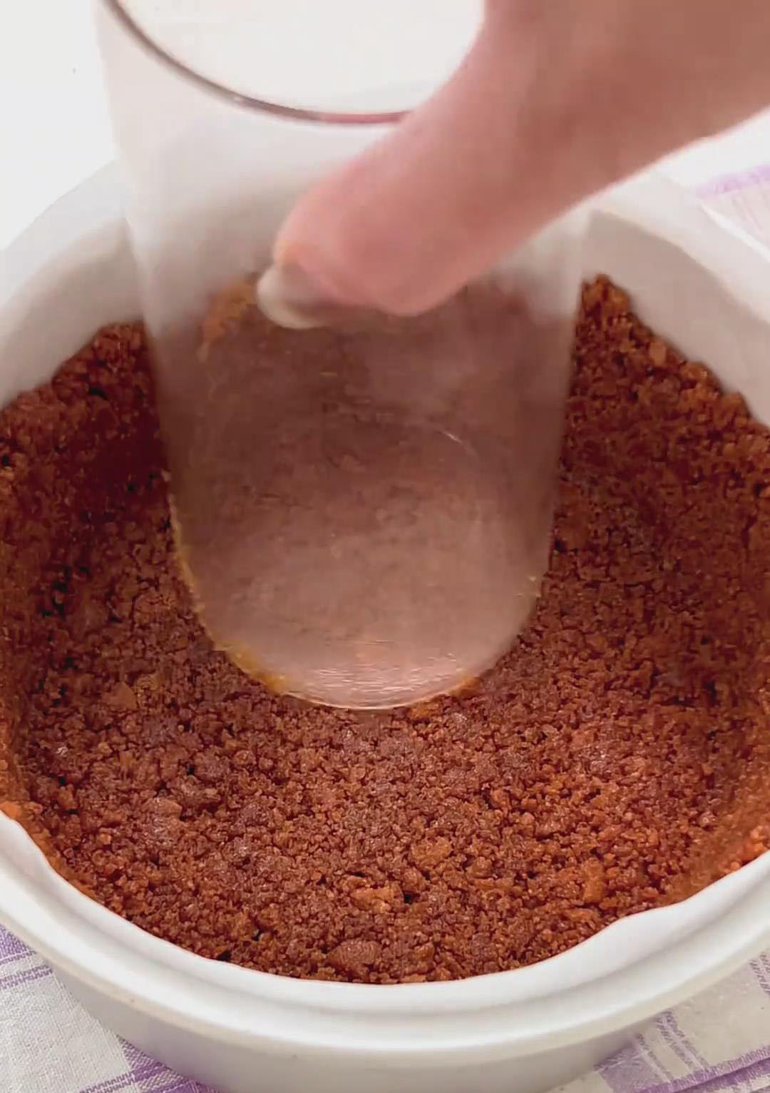 Press firmly using the bottom of a glass to compact the crust and build clean edges