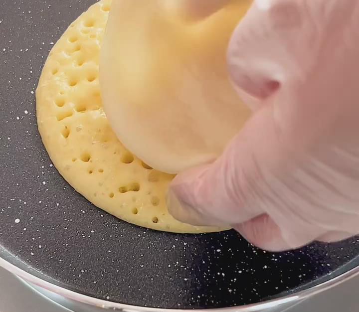 place one of your prepared mochi discs directly onto the center of the uncooked surface of the pancake