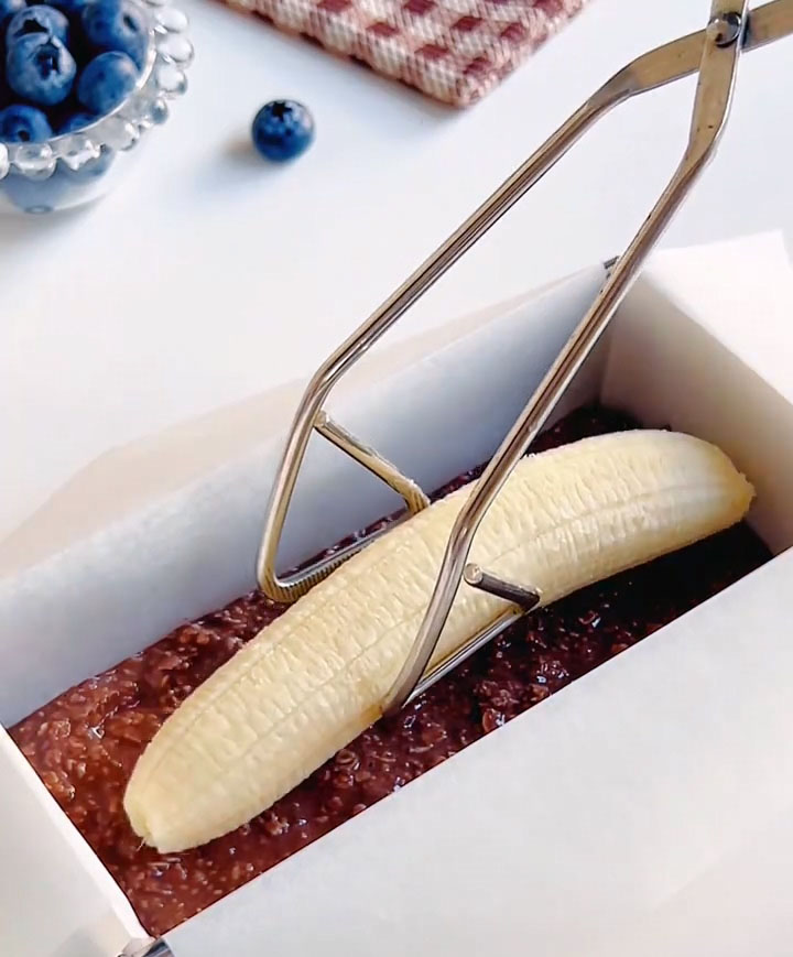 Take your remaining whole banana and gently place it lengthwise right down the center of the batter