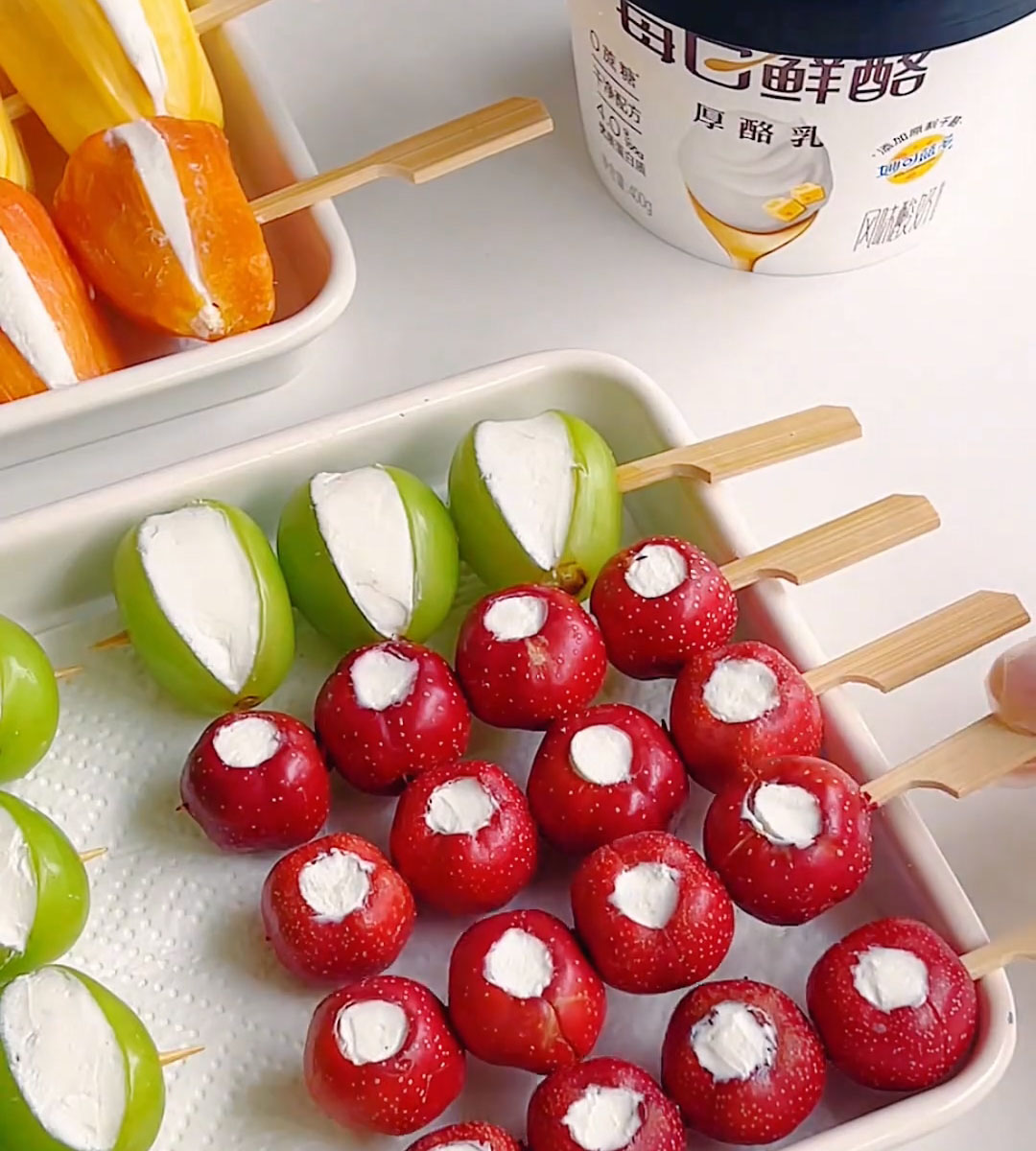 Thread 3 4 pieces of yogurt filled fruit onto each bamboo skewer