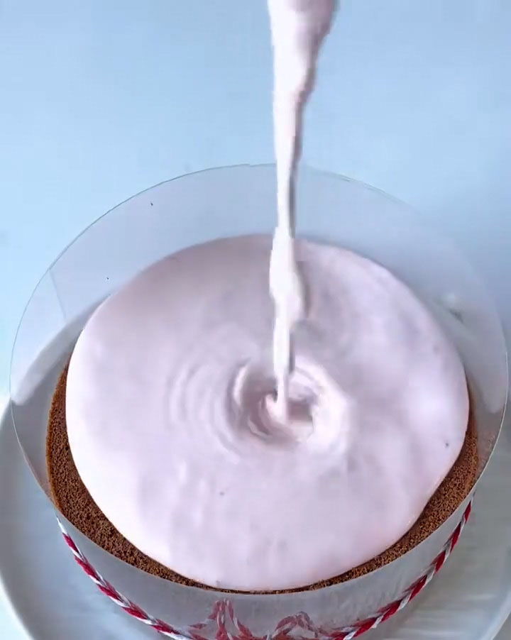 our the strawberry mousse over the chocolate cake layer in the prepared pan