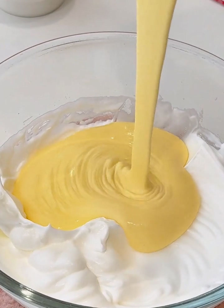 pour this mixture back into the bowl with the remaining two thirds of the meringue