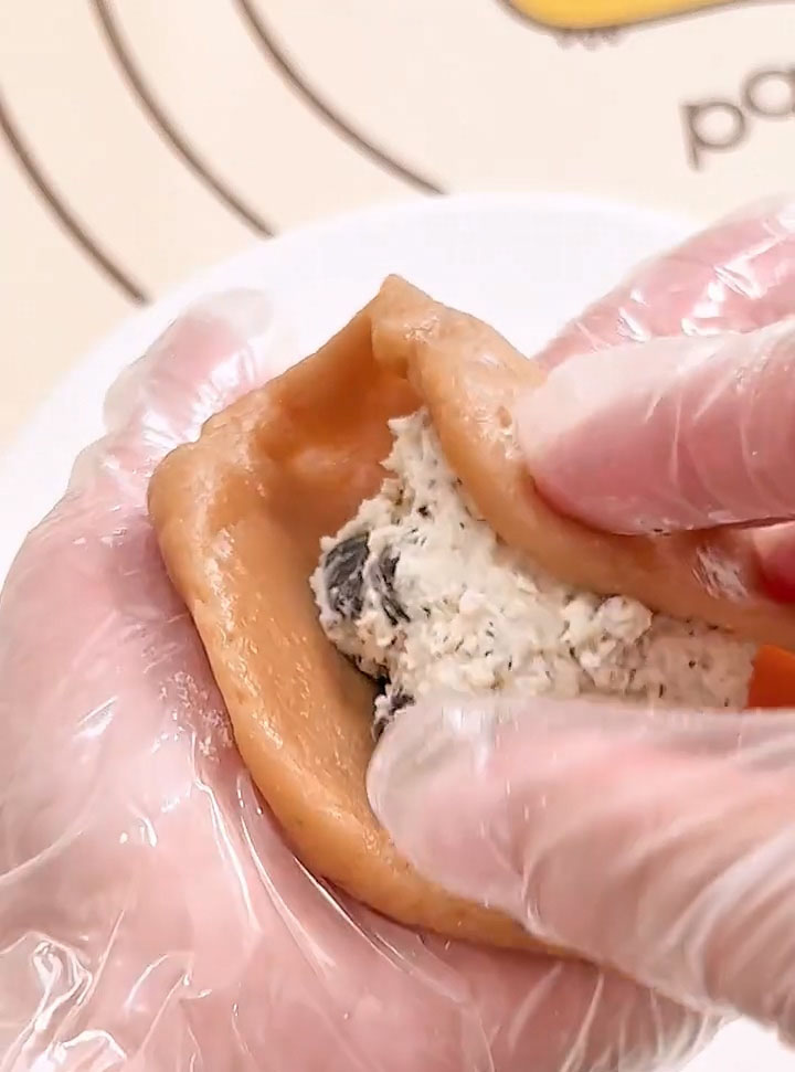 Gently cup the disc in your hand and use your other hand to push the skin upward around the filling