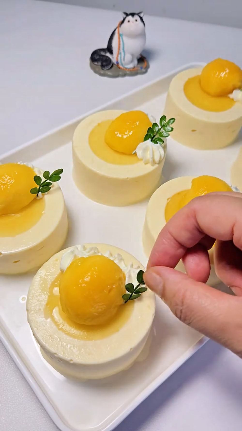 Pipe a small amount of heavy cream on top for decoration and garnish with fresh mango cubes