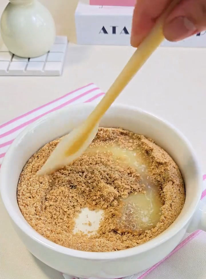 Pour in the 40 g of melted unsalted butter and mix with a fork or spatula until all the crumbs are evenly coated and resemble wet sand