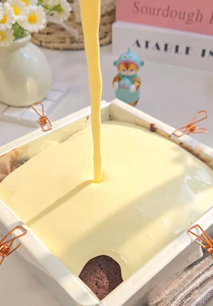 Pour the cheesecake mixture over the completely cooled brownie layer