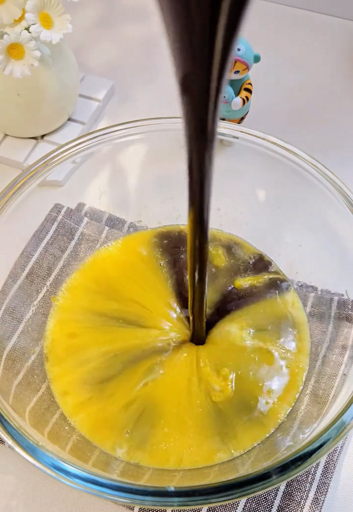 Pour the cooled chocolate butter mixture into the egg mixture