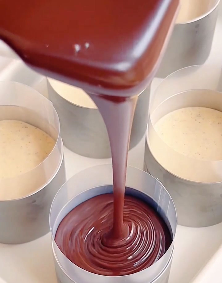 Pour the cooled chocolate mixture evenly over each cheesecake