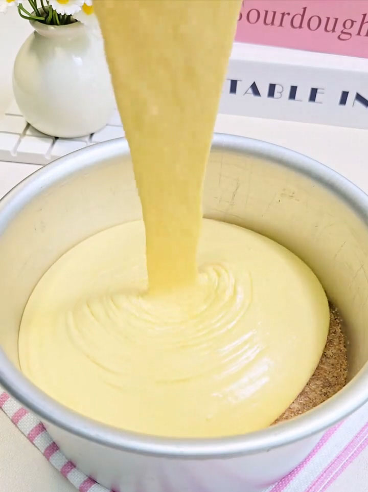 Pour the mango mousse onto the prepared biscuit base