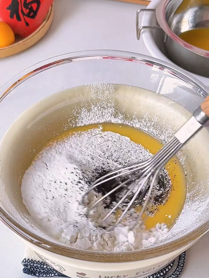 Sift 48 g cake flour into the bowl to ensure no lumps remain. Add 2 g Earl Grey tea powder