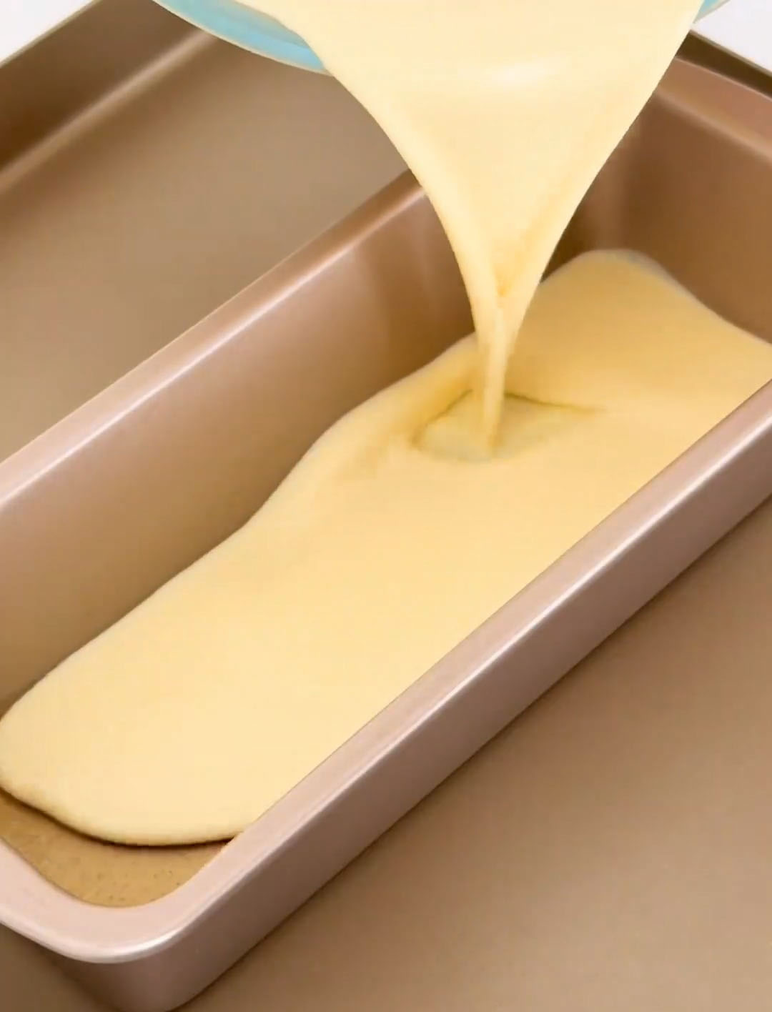 Slowly pour the strained custard into the molds over the hardened caramel