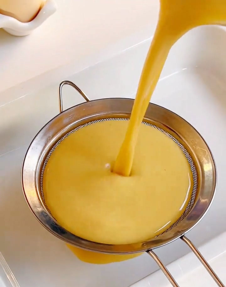 Strain the egg mixture into a shallow dish