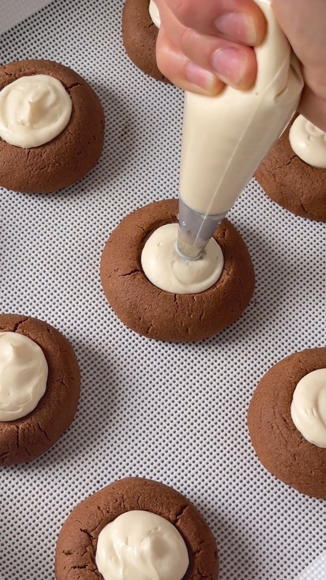 pipe the cream cheese filling onto the flattened center of each cookie