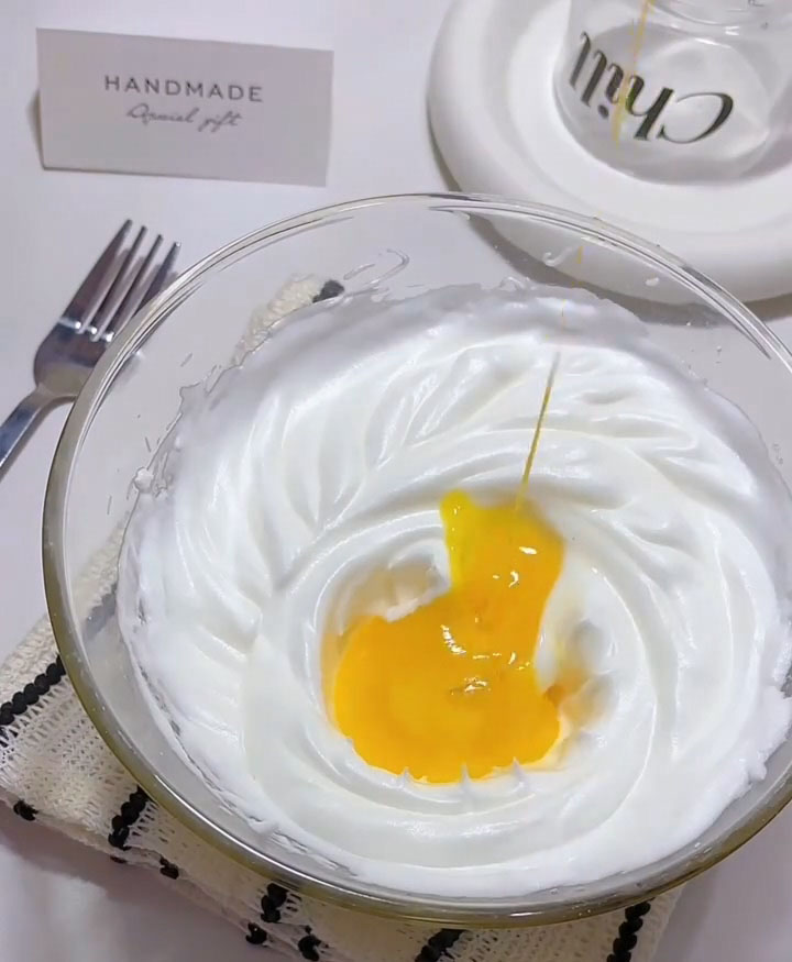 Add the egg yolks to the whipped meringue