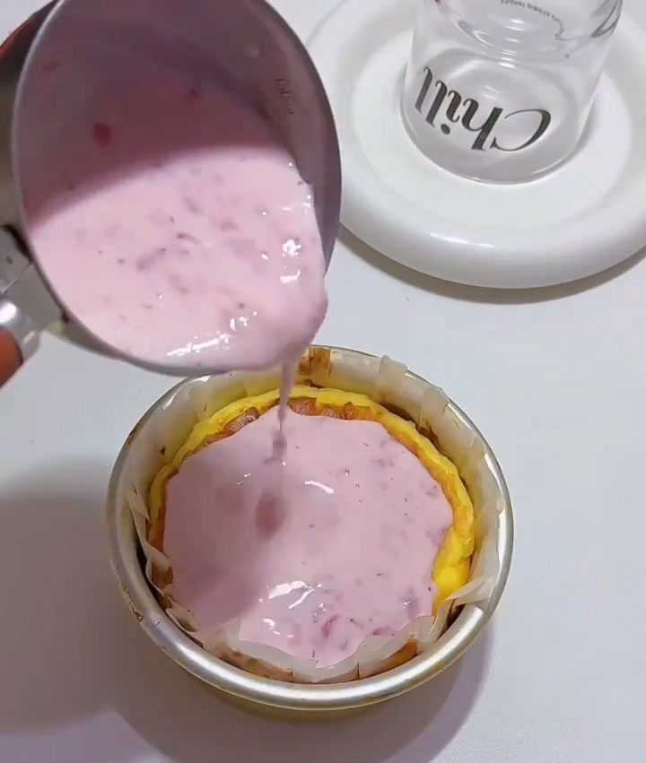 Gently and slowly pour the strawberry mousse mixture over the completely cooled Basque layer