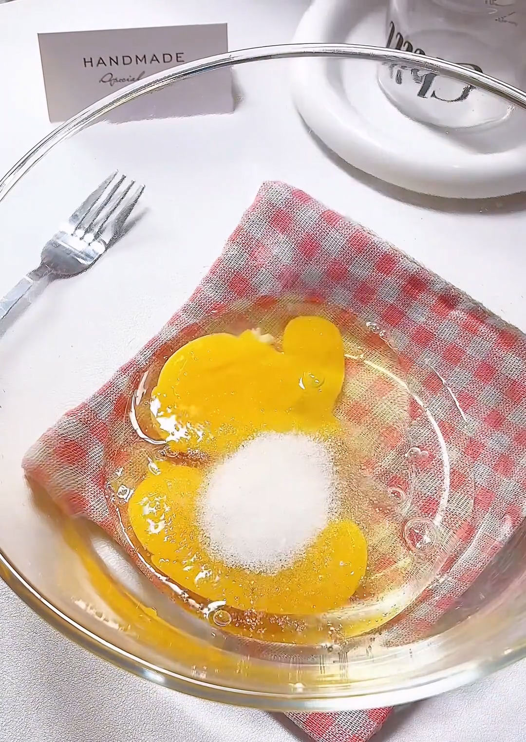 In a medium mixing bowl, crack 2 eggs and add 15g white sugar