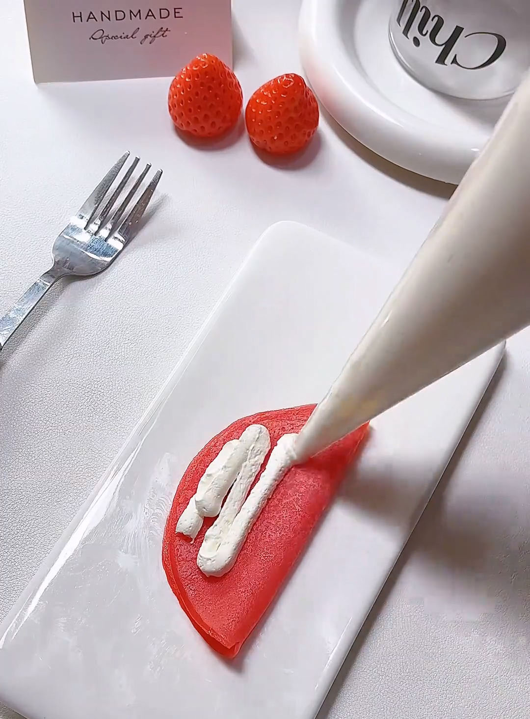 Pipe a line of whipped cream along the straight edge of the folded crepe