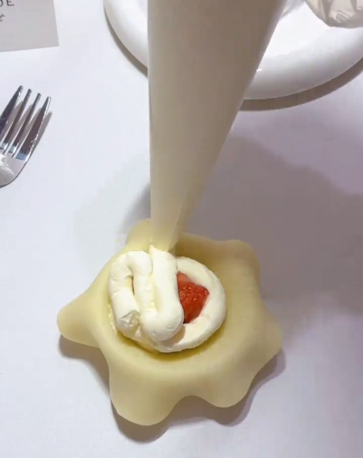 Pipe more whipped cream around and over the strawberry.