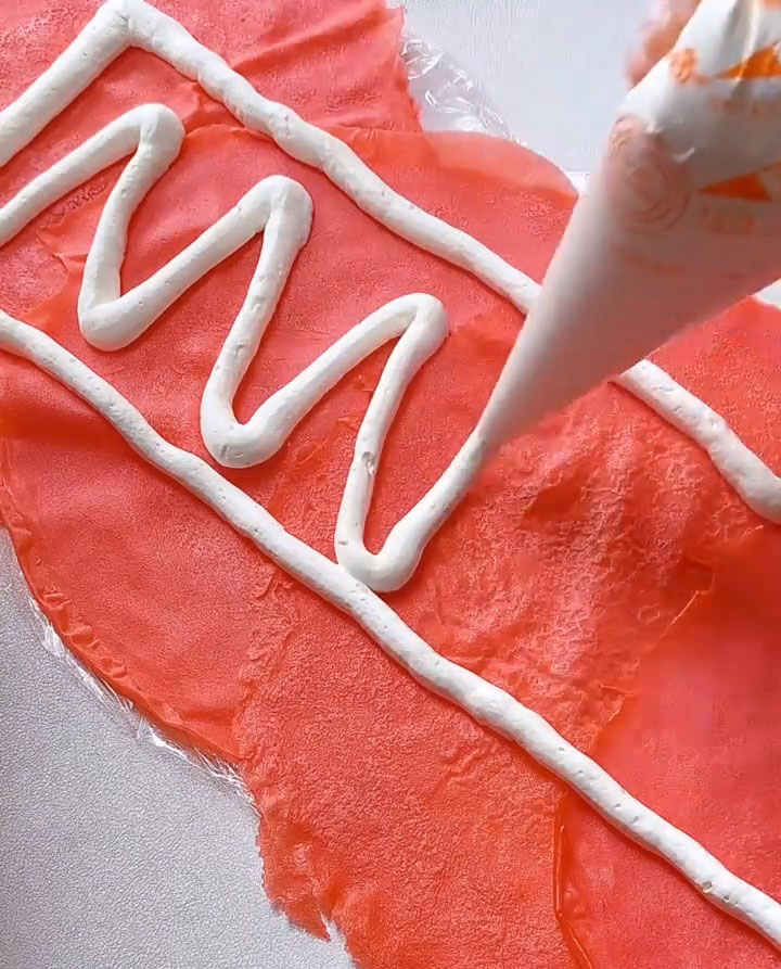 Pipe or spoon a generous, even layer of the whipped cream over the entire surface of the overlapping crepes