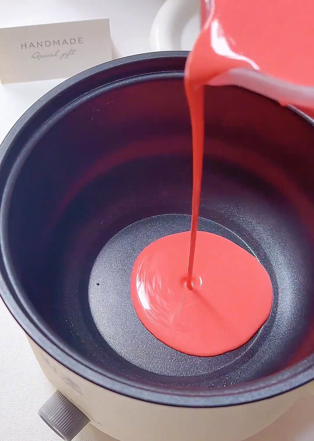 Pour a small amount of batter into the center of the pan