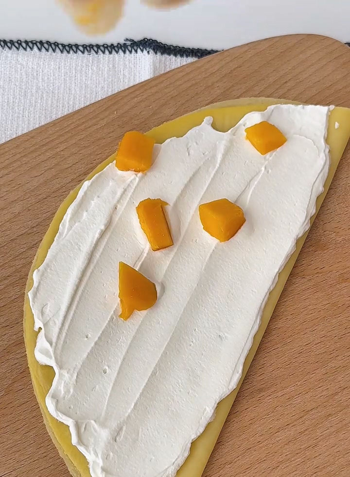 Scatter fresh mango cubes over the cream