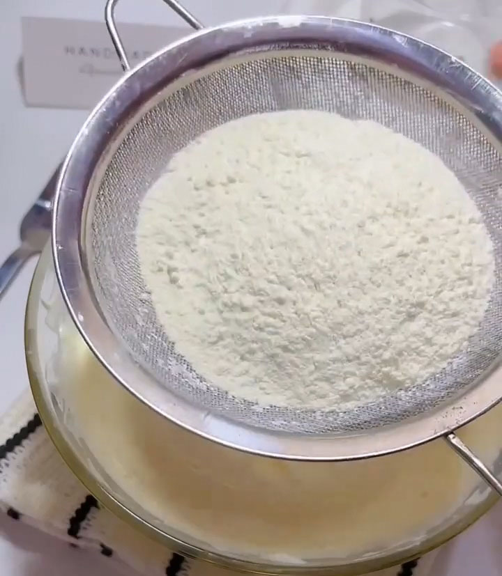 Sift 60g of cake flour directly over the egg mixture