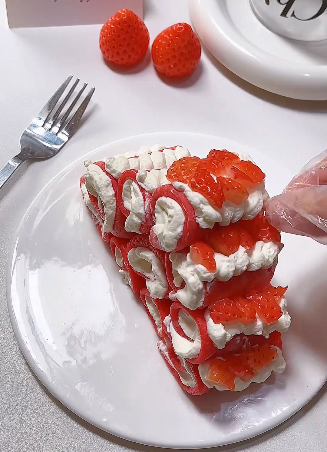 Top each cream dollop with a small strawberry piece