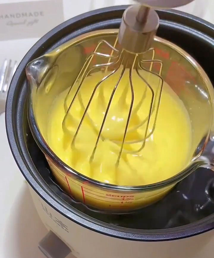 Using a hand mixer or whisk, beat continuously until the mixture becomes thick, pale, and fluffy