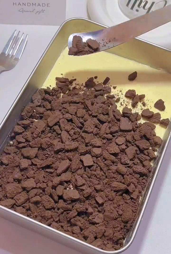 sprinkle a generous layer of Oreo crumbs evenly over the top of the tiramisu